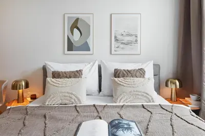 a bedroom with a bed with two lamps and two pictures at Prague Days - Studio with Outdoor Seating close to Vyšehrad in Prague