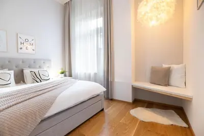 a white bedroom with a bed and a window at Negrelli Residence - main BUS station in Prague