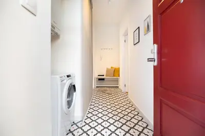 a washing machine in a hallway with a red door at Negrelli Residence - main BUS station in Prague