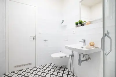 a white bathroom with a toilet and a sink at Negrelli Residence - main BUS station in Prague