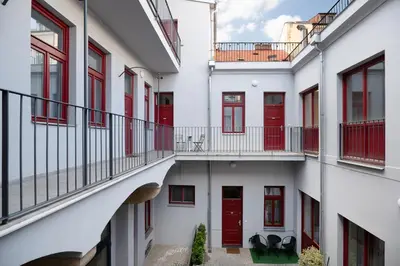 an apartment building with red doors and balconies at Negrelli Residence - main BUS station in Prague