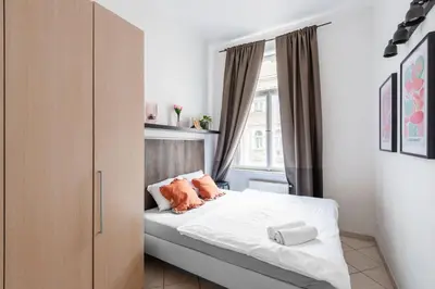 a small bedroom with a bed and a window at Tyrsova Apartment in Prague