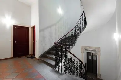 a spiral staircase in a house with a red door at Tyrsova Apartment in Prague