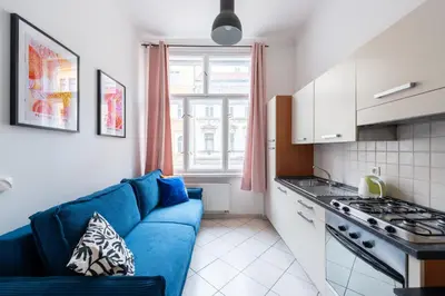 a living room with a blue couch in a kitchen at Tyrsova Apartment in Prague