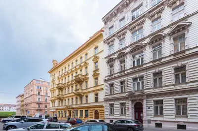 a large building with cars parked in front of it at Tyrsova Apartment in Prague