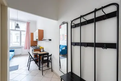 a room with a mirrored closet with a table and a desk at Tyrsova Apartment in Prague