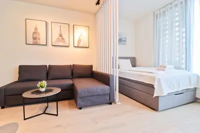 a living room with a bed and a couch at Sunny Apartment in Smichov, Prague 5 in Prague