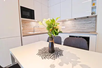 a vase with flowers on a table in a kitchen at Sunny Apartment in Smichov, Prague 5 in Prague