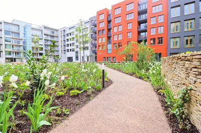 a garden with flowers and buildings in the background at Sunny Apartment in Smichov, Prague 5 in Prague