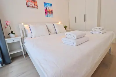 a white bed with towels on it in a room at Sunny Apartment in Smichov, Prague 5 in Prague