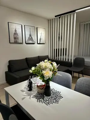 a living room with a table with a vase of flowers at Sunny Apartment in Smichov, Prague 5 in Prague