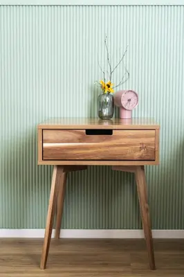 a wooden table with a vase of flowers and a clock at Prague City Golf Apartments in Prague
