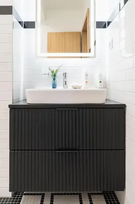 a bathroom with a black cabinet with a sink at Prague City Golf Apartments in Prague