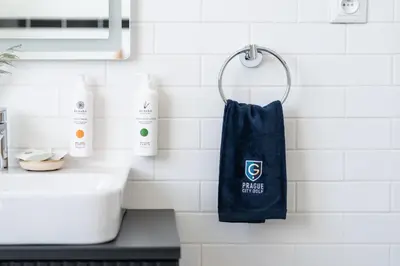a blue towel hanging on a wall next to a sink at Prague City Golf Apartments in Prague