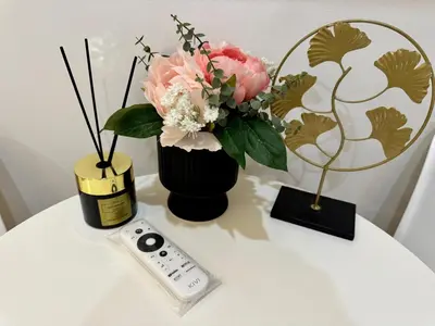 a table with a vase of flowers and a remote control at Zitna Downtown Apartments in Prague