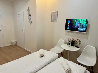 a room with two beds and a tv on the wall at Zitna Downtown Apartments in Prague
