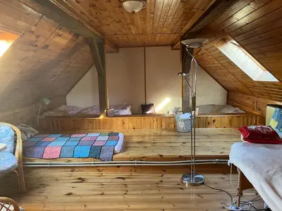 a room with a bed in a wooden cabin at Cat’s House- Dům u třech koček in Zdice