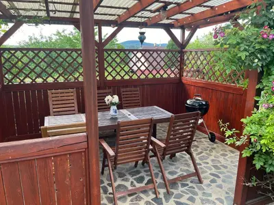 a wooden pergola with a table and chairs on a patio at Cat’s House- Dům u třech koček in Zdice