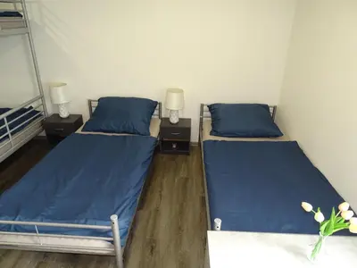 two beds in a room with blue sheets and lamps at Apartmán Nebužely in Nebužely