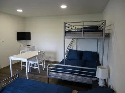 a room with a bunk bed with a desk and a table at Apartmán Nebužely in Nebužely