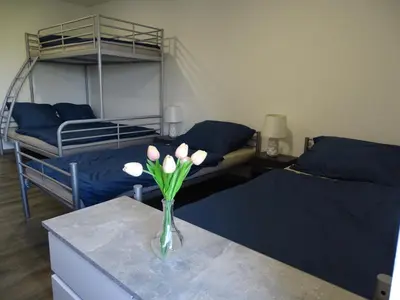 a room with two beds and a vase with flowers on a table at Apartmán Nebužely in Nebužely