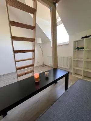 a living room with a black table and a loft at Studio Prosecká vyhlídka in Prague
