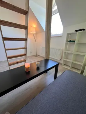 a living room with a black table and a window at Studio Prosecká vyhlídka in Prague