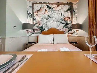 a bedroom with a bed with a flower mural on the wall at ELSO Muzeum apartments in Prague