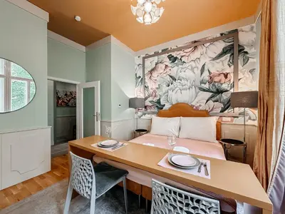 a room with a bed and a table and chairs at ELSO Muzeum apartments in Prague