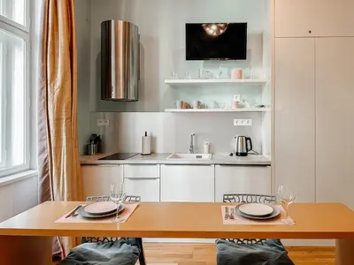 a kitchen with a wooden table and a sink at ELSO Muzeum apartments in Prague