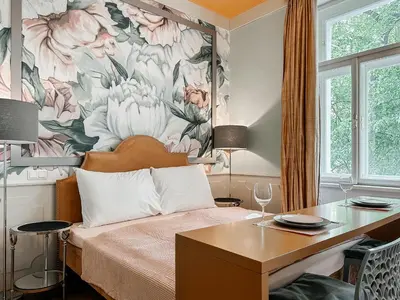 a bedroom with a bed and a floral wall at ELSO Muzeum apartments in Prague