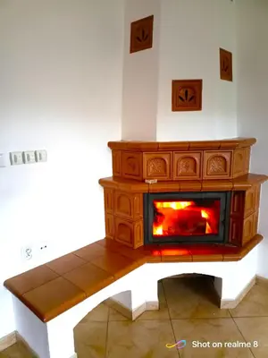 a woodburning stove in a living room with at Apartmán Srubík in Čisovice