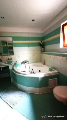 a bath tub in a bathroom with green and white stripes at Apartmán Srubík in Čisovice