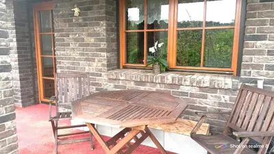 a wooden table and two chairs in front of a house at Apartmán Srubík in Čisovice
