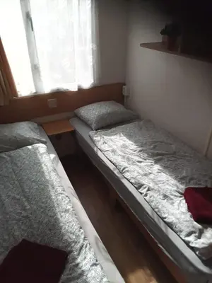 two beds in a small room with a window at Mobilní dům Venda in Hradištko