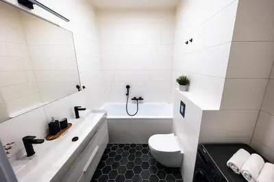a white bathroom with a tub and a toilet at 3BR AC Heaven of Harmony LUXPenthouse Theater view in Prague