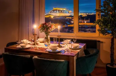 a dining table with a view of a cruise ship at 3BR AC Heaven of Harmony LUXPenthouse Theater view in Prague