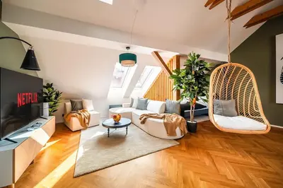a living room with two swinging chairs and a couch at 3BR AC Heaven of Harmony LUXPenthouse Theater view in Prague