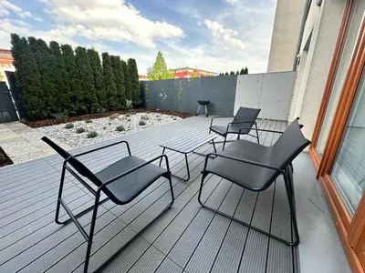 a patio with four chairs and a table on a deck at IOS Garden in Prague