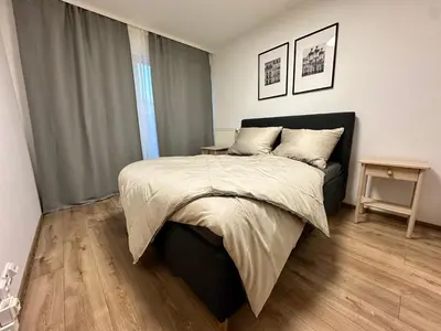 a bedroom with a large bed and a wooden floor at IOS Garden in Prague
