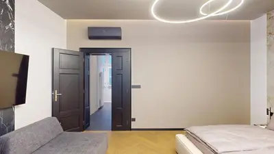 a bedroom with a bed and a tv on the wall at Naprstek Castle View Residence in Prague