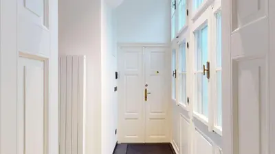 a hallway with white walls and white doors at Naprstek Castle View Residence in Prague
