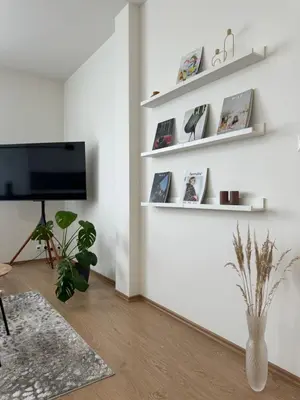 a living room with white walls and a flat screen tv at 96m2 Designer Apartment, FREE Garage Parking in Prague