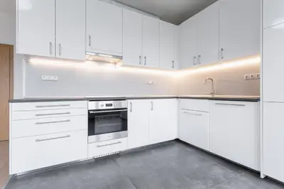 a white kitchen with white cabinets and a sink at 96m2 Designer Apartment, FREE Garage Parking in Prague