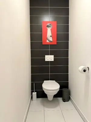 a bathroom with a toilet and a picture on the wall at 96m2 Designer Apartment, FREE Garage Parking in Prague