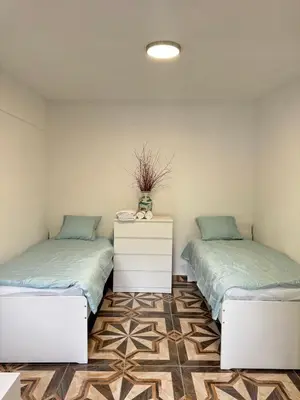 two beds sitting next to each other in a room at 布拉格城堡公寓 in Rudná