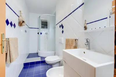 a white bathroom with a toilet and a sink at Romantic apartment by the park - uaka7 in Prague