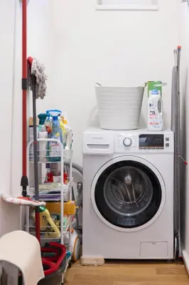 a washing machine in a laundry room with a stack of dishes at Family Friendly Spacious Two Floor B&B Prague in Prague
