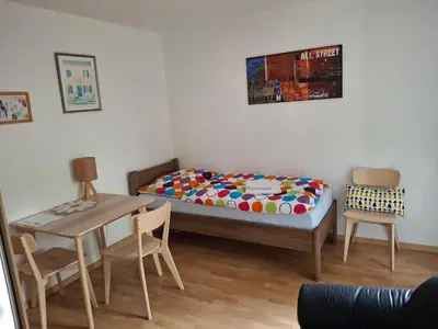 a bedroom with a bed and a table and chairs at Apartmán Hajní 1368 in Prague