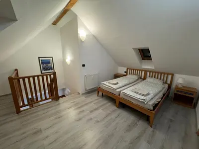 a bedroom with a bed and a wooden floor at Vitkova Duplex apartment with terrace near Florenc in Prague